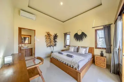 a bedroom with a bed and a desk and windows at Villa Kumaru Luxury 4BR inc breakfast and airport pickup in Canggu