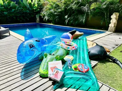 a table with a shark head next to a swimming pool at Villa Kumaru Luxury 4BR inc breakfast and airport pickup in Canggu