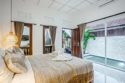a bedroom with a bed and a large window at Villa Jasmine by JB VIllas in Seminyak