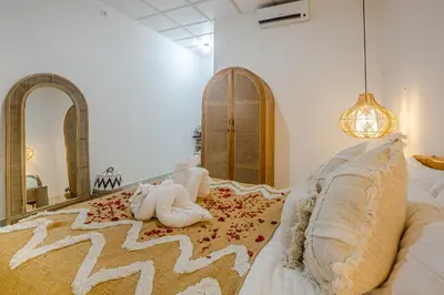 a bedroom with a bed with a teddy bear laying on a rug at Villa Jasmine by JB VIllas in Seminyak