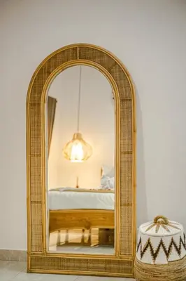 a wicker mirror in a room with a bed at Villa Jasmine by JB VIllas in Seminyak