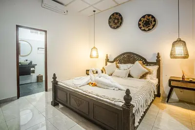 a bedroom with a bed and a piano at Villa Jasmine by JB VIllas in Seminyak