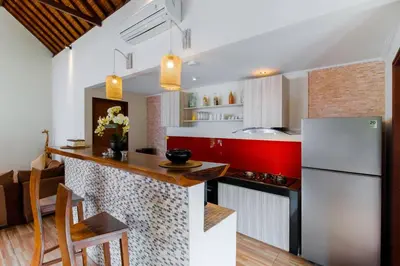 a kitchen with a white refrigerator and a red counter top at Villa Tranquil Holiday Villa in Seminyak