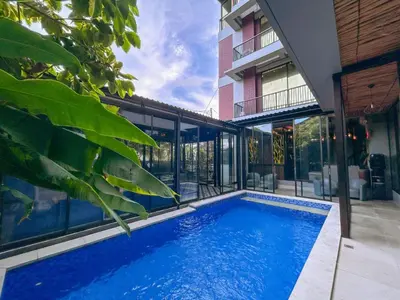 a swimming pool in front of a house at YuRooms Villapartment - Love Room Bali in Jimbaran