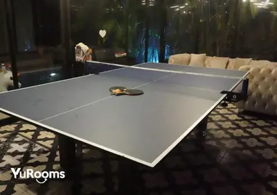 a ping pong table with a pair of scissors on it at YuRooms Villapartment - Love Room Bali in Jimbaran