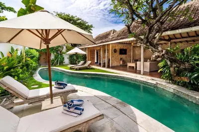 an image of a swimming pool with an umbrella and chairs at Villa Amsa by Pertama Management in Seminyak