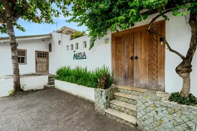 a house with a wooden door and a tree at Villa Amsa by Pertama Management in Seminyak