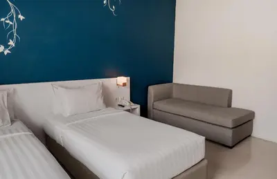 a small bedroom with a bed and a chair at Cozy Stay Bali by ARM Hospitality in Seminyak