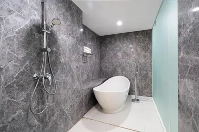 a bathroom with a shower with a toilet and a sink at Cozy Stay Bali by ARM Hospitality in Seminyak