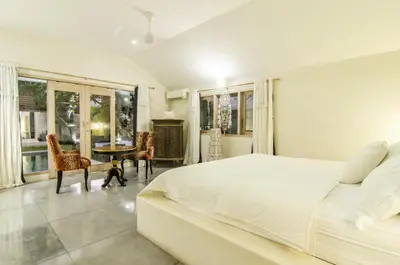 a bedroom with a white bed and a table and chairs at Luxurious&Spacious 4Br Villa in Seminyak in Seminyak