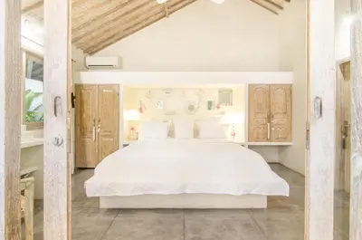 a bedroom with a white bed and wooden cabinets at Luxurious&Spacious 4Br Villa in Seminyak in Seminyak