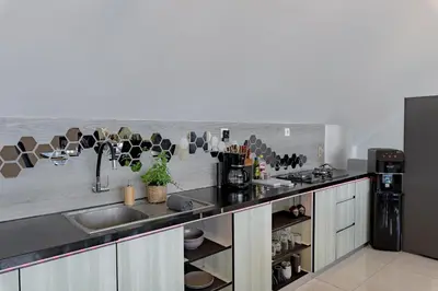 a kitchen with a sink and a counter with cups on the wall at Beautiful Penthouse w/ incredible views, pool, & cinema room! in Canggu