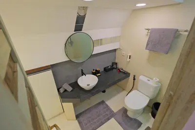 a bathroom with a sink and a mirror and a toilet at Beautiful Penthouse w/ incredible views, pool, & cinema room! in Canggu