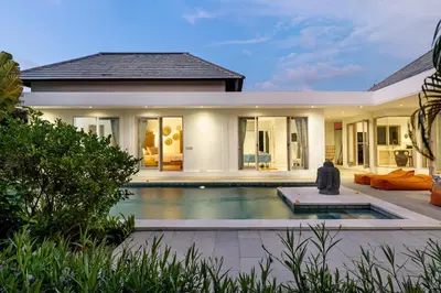 a villa with a swimming pool in front of a house at Wonderful 4Br Villa in Seminyak in Seminyak