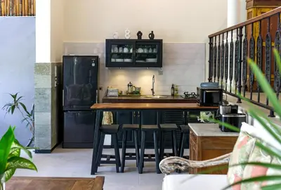 a kitchen with a counter and a bar with stools at Villa Baruna Seminyak in Seminyak