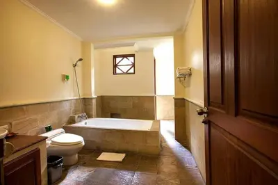 a bathroom with a tub and a toilet and a sink at Clasic Private Pool Villa in Seminyak in Seminyak