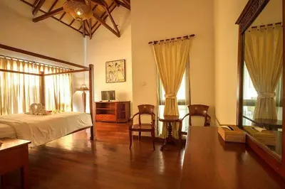 a bedroom with a bed and chairs in a room at Clasic Private Pool Villa in Seminyak in Seminyak