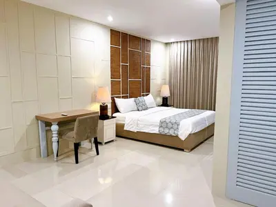 a bedroom with a bed and a desk and a table at Astana Residence in Seminyak