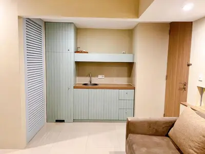 a kitchen with a sink and a couch in a room at Astana Residence in Seminyak