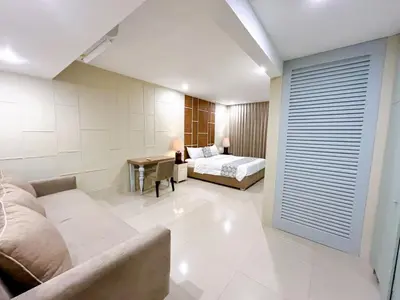 a bedroom with a bed and a desk in a room at Astana Residence in Seminyak