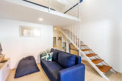 a living room with a blue couch and a staircase at The Blue Loft Seminyak free scooter in Seminyak