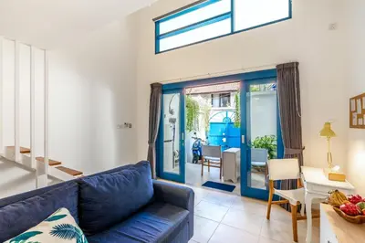 a living room with a blue couch and a table at The Blue Loft Seminyak free scooter in Seminyak
