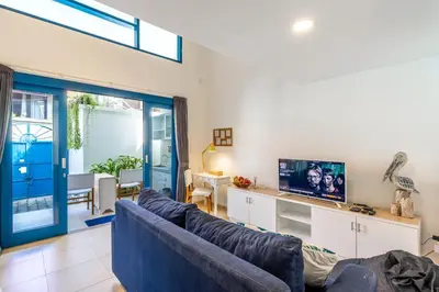 a living room with a blue couch and a tv at The Blue Loft Seminyak free scooter in Seminyak