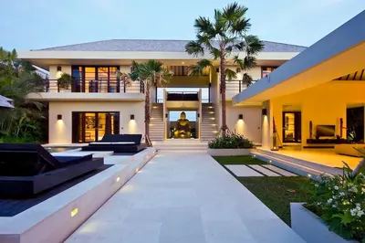 a house with palm trees in front of it at Exquisite 4BD Luxury Villa in the Heart of Berawa in Canggu