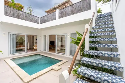 a villa with a swimming pool and stairs at Bloom Umalas Villa by Betterplace in Canggu