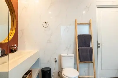 a bathroom with a toilet and a mirror at Bloom Umalas Villa by Betterplace in Canggu