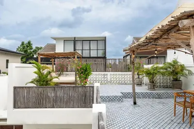 a patio with a fence and a table and chairs at Bloom Umalas Villa by Betterplace in Canggu