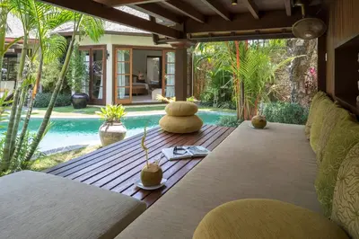 a living room with a couch and a swimming pool at LataLiana Seminyak in Seminyak