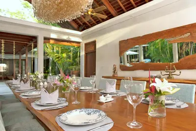 a long wooden table with plates and wine glasses at LataLiana Seminyak in Seminyak