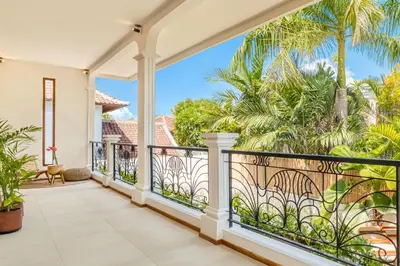 a balcony with a view of palm trees at Villa San Diego: Brand New 4BDR in Seminyak