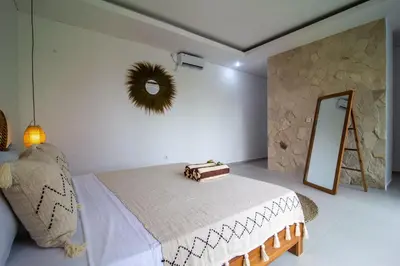 a white bedroom with a bed and a mirror at Simple & Magical Villas Almaya 2 in Canggu