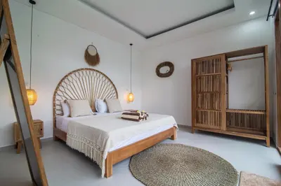 a bedroom with a large bed and a mirror at Simple & Magical Villas Almaya 2 in Canggu