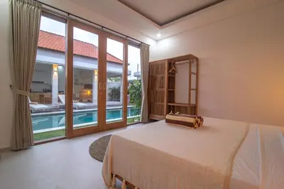 a bedroom with a bed and a large window at Simple & Magical Villas Almaya 2 in Canggu