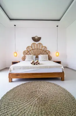 a bedroom with a large bed with a wooden headboard at Simple & Magical Villas Almaya 2 in Canggu
