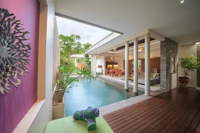 a house with a swimming pool and a living room at The Kasih Villas & Spa in Seminyak