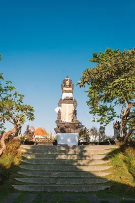 a monument on a set of stairs with trees at The Kasih Villas & Spa in Seminyak