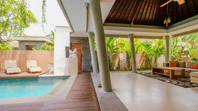 an outdoor living area with a swimming pool and a villa at The Kasih Villas & Spa in Seminyak