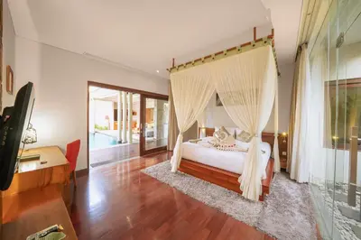 a bedroom with a bed with a mosquito net at The Kasih Villas & Spa in Seminyak