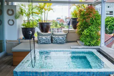 a swimming pool on a balcony with potted plants at Private Penthouse with Sunset Views Central Seminyak in Seminyak