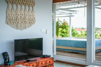 a living room with a flat screen tv and a window at Private Penthouse with Sunset Views Central Seminyak in Seminyak