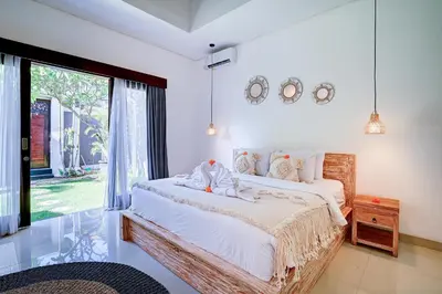 a bedroom with a bed and a large window at Villa O'Anne in Seminyak