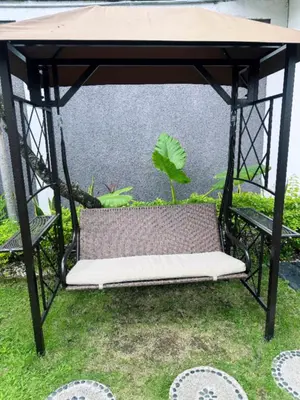 a swing bed in a garden with a plant at Villa O'Anne in Seminyak