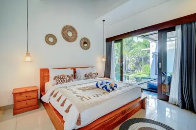 a bedroom with a bed and a large window at Villa O'Anne in Seminyak