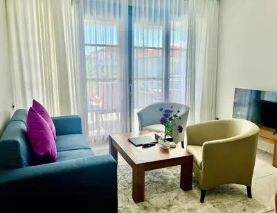 a living room with a couch and two chairs and a table at The Bay Sunflower Apartment in Nusa Dua