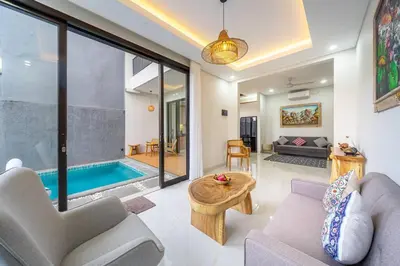a living room with a couch and a pool at TC Villa Taman Mumbul Nusa Dua in Nusa Dua