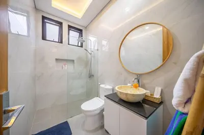 a bathroom with a sink and a toilet and a mirror at TC Villa Taman Mumbul Nusa Dua in Nusa Dua